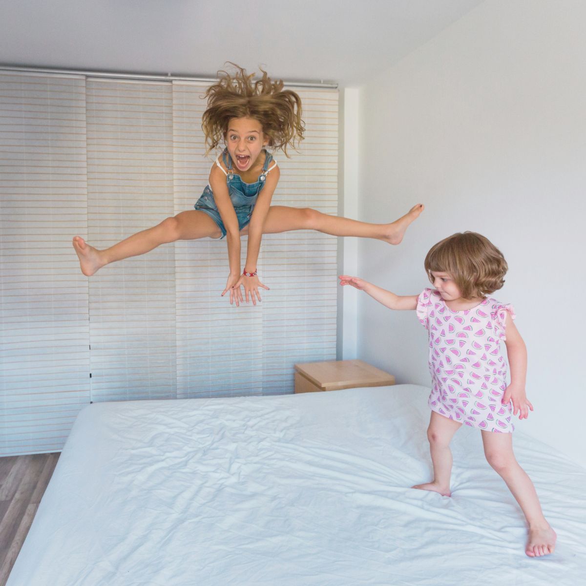 Two kids jumping up and down on Subrtex mattress topper