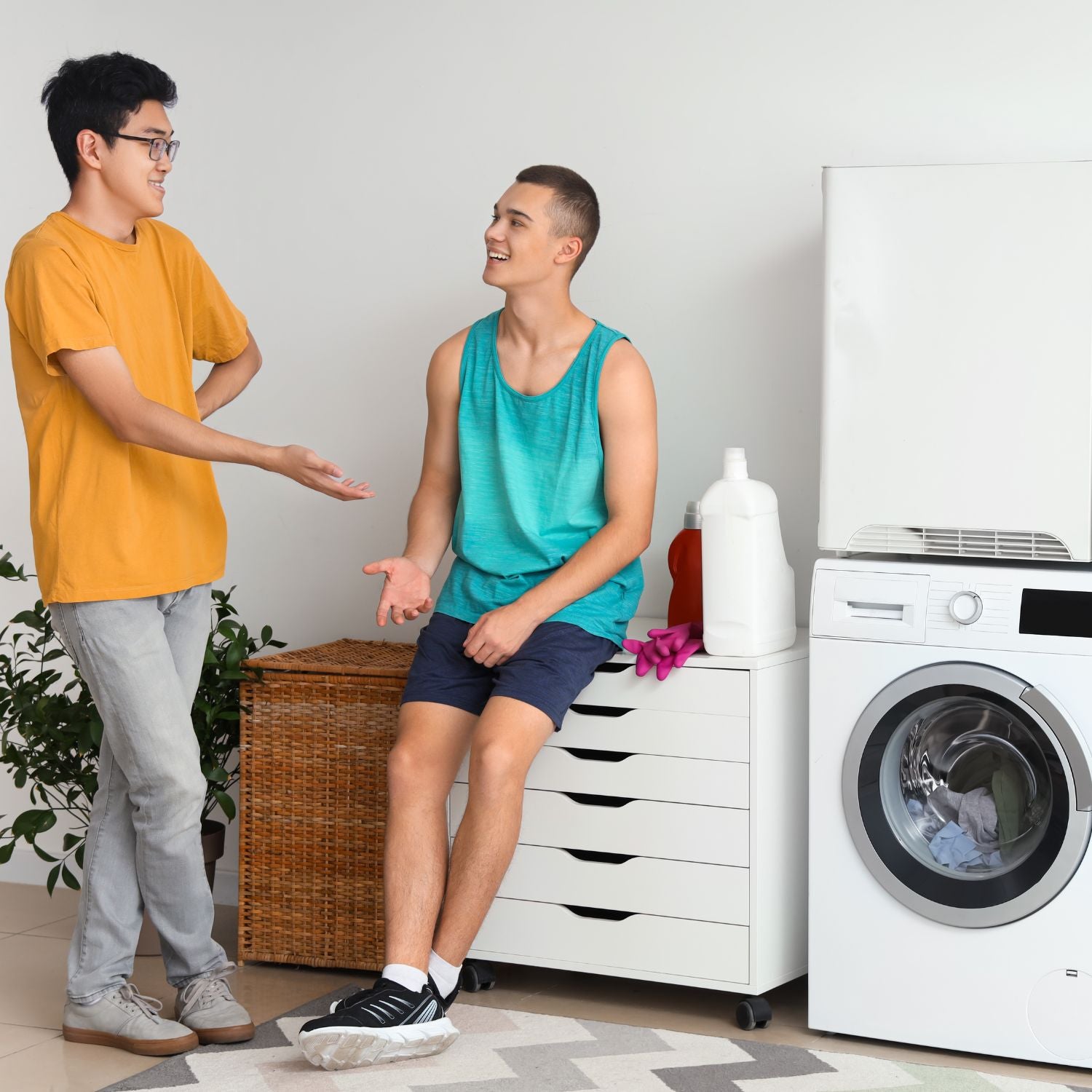 Two students chat in laundry room while waiting for mattress topper cover to be cleaned